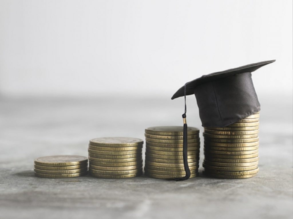 Stacked coins with graduation hat