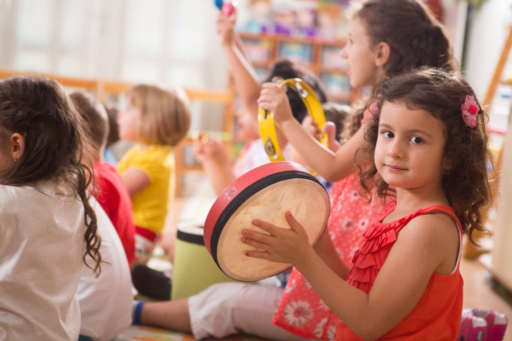 Little girl playing tambourine