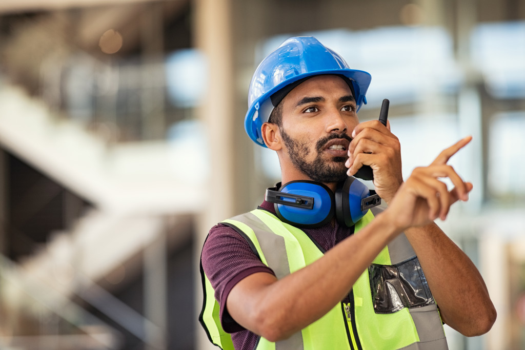 Construction worker using a two-way radio at a construction site. 